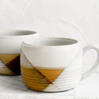 2: A mug with mix of brown and white glazes forming geometric pattern.