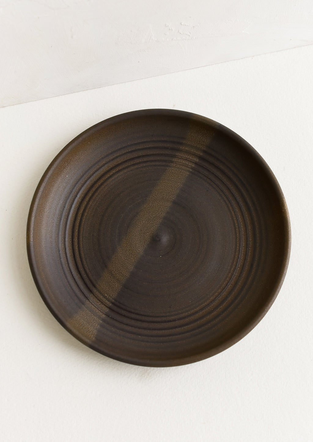 Matte Earth / Dessert Plate: A ceramic side plate in a matte dark brown glaze.