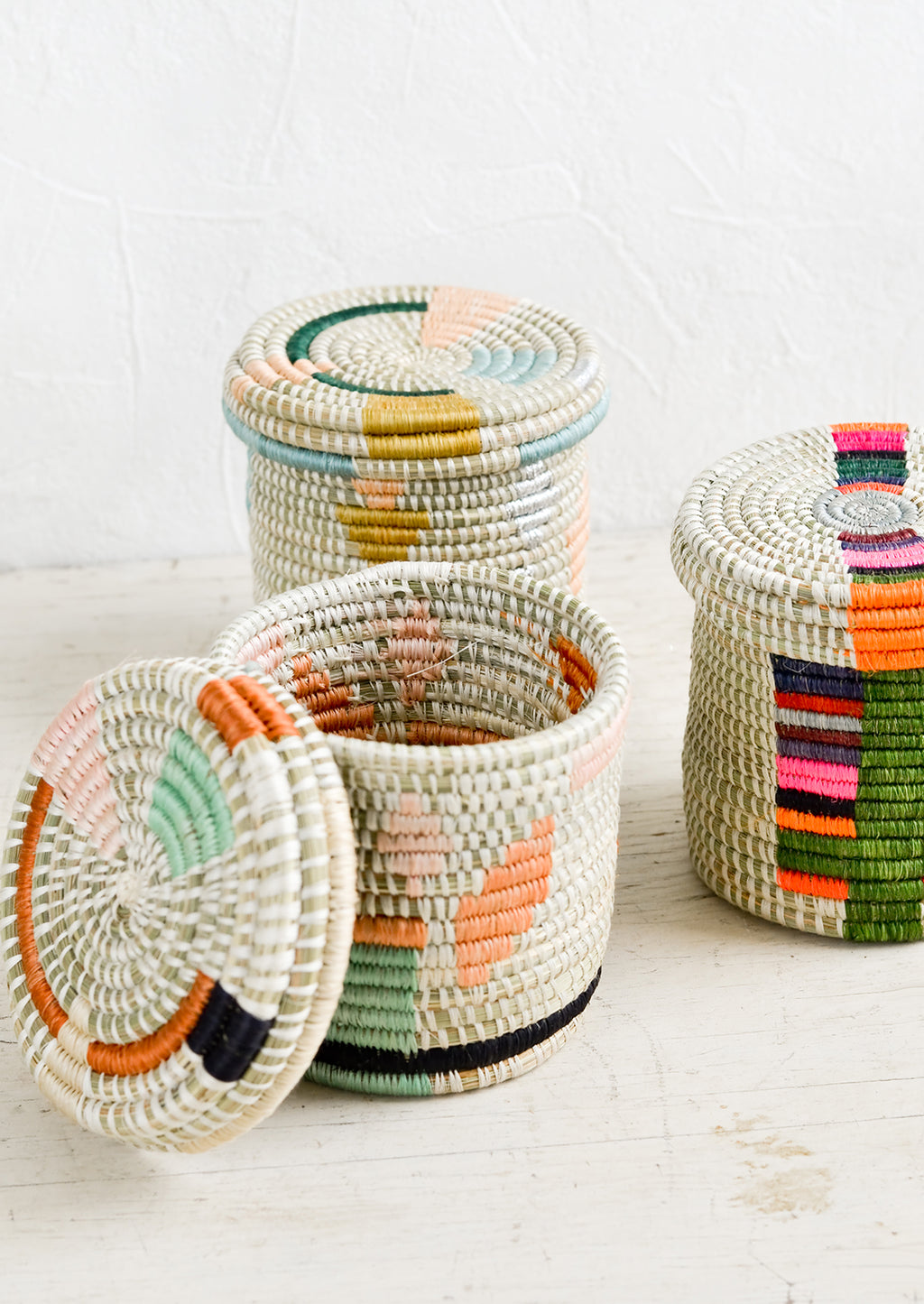 2: Assorted lidded woven baskets in a mix of colors and patterns.