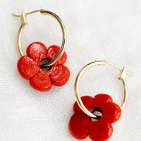 Cherry: A pair of gold hoop earrings with single red flower bead.