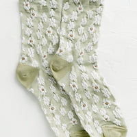Mint: A pair of non-sheer yellow socks in mint with allover white daisy pattern.
