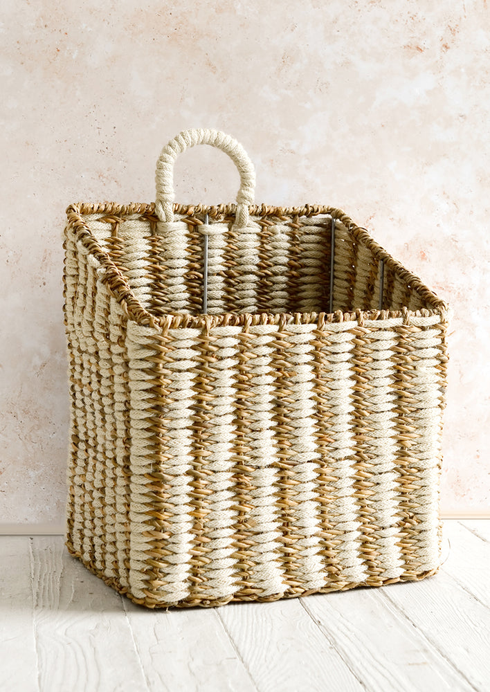 1: A structured square storage basket with tapered front and higher back with single handle.