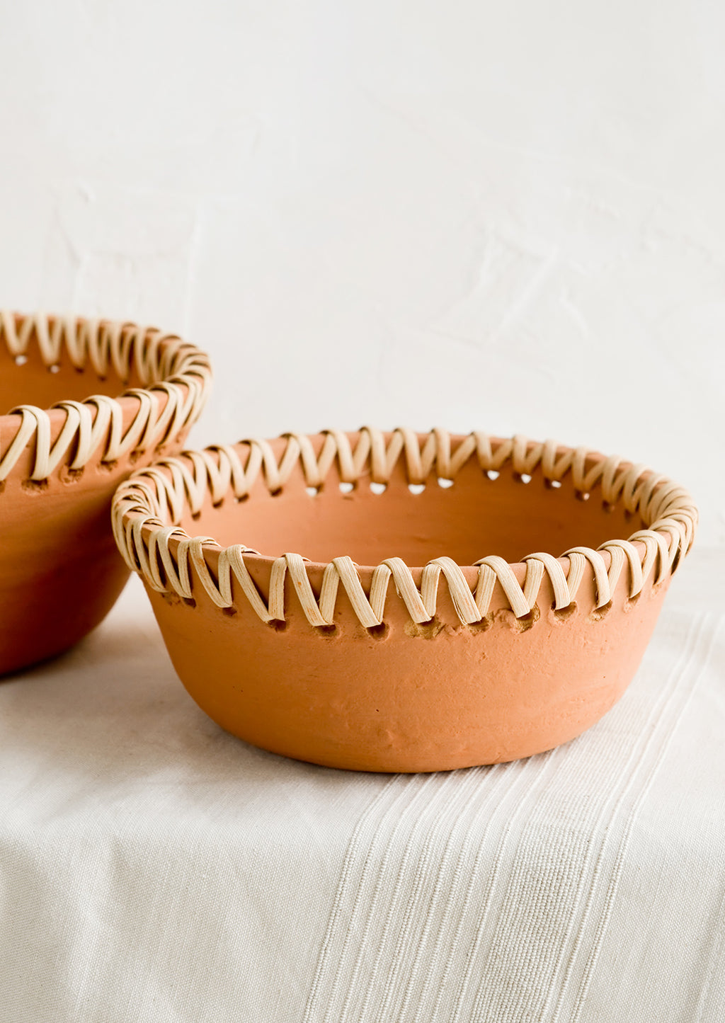 1: Terracotta bowl with decorative woven seagrass trim around top.