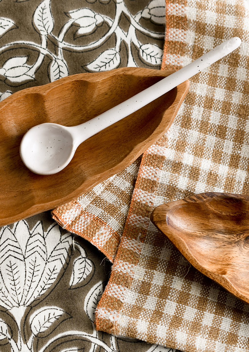 2: Wooden dishes styled with textiles and spoon.
