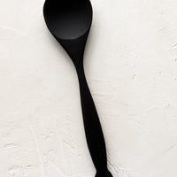Serving Spoon: A carved black wooden spoon with decoratively curved handle.
