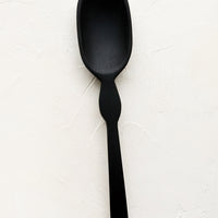 Standard: A carved black wooden spoon with decoratively curved handle.
