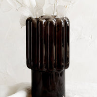 2: A large glass vase in dark brown with fluted texture.