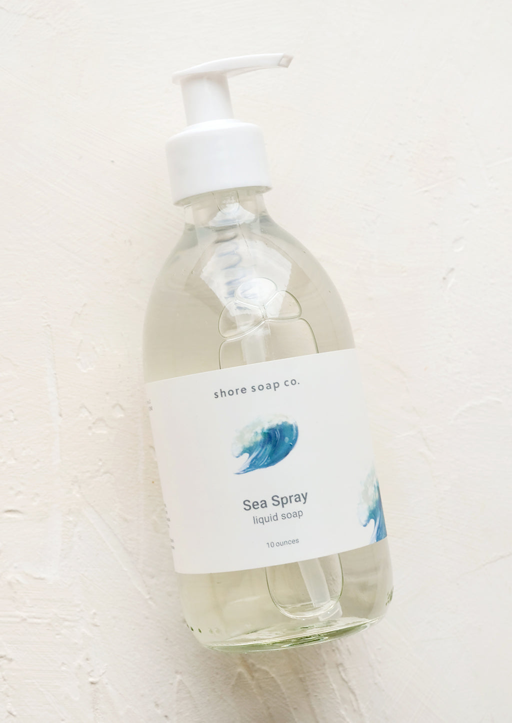 Sea Spray: A glass pump bottle containing liquid soap in "Sea spray" scent.