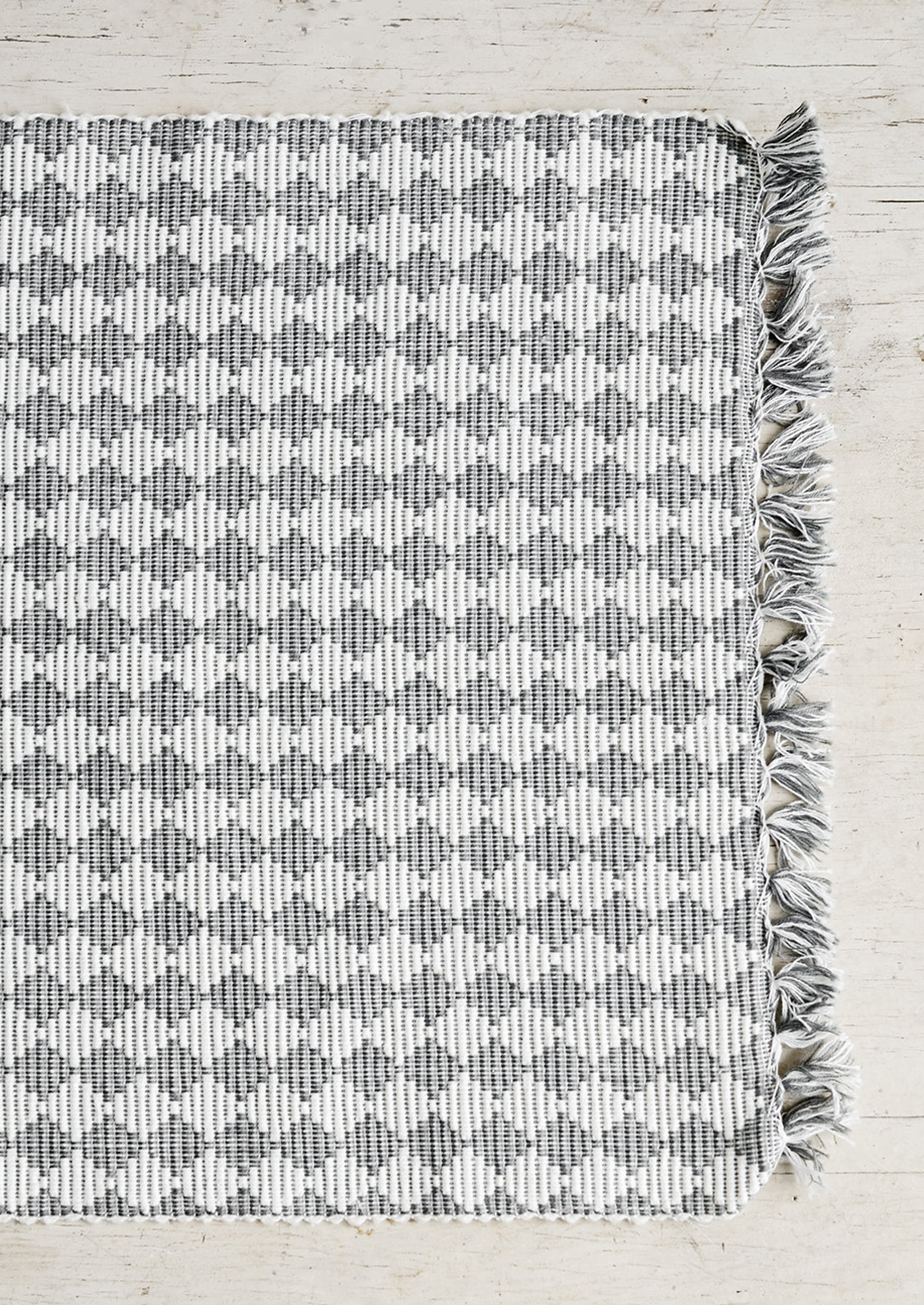 A table runner in ribbed textured grey and white checker print.