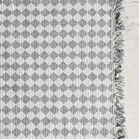 1: A grey and white placemat with triangular checkered pattern.