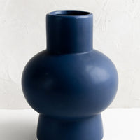 1: A navy blue sculptural ceramic vase.