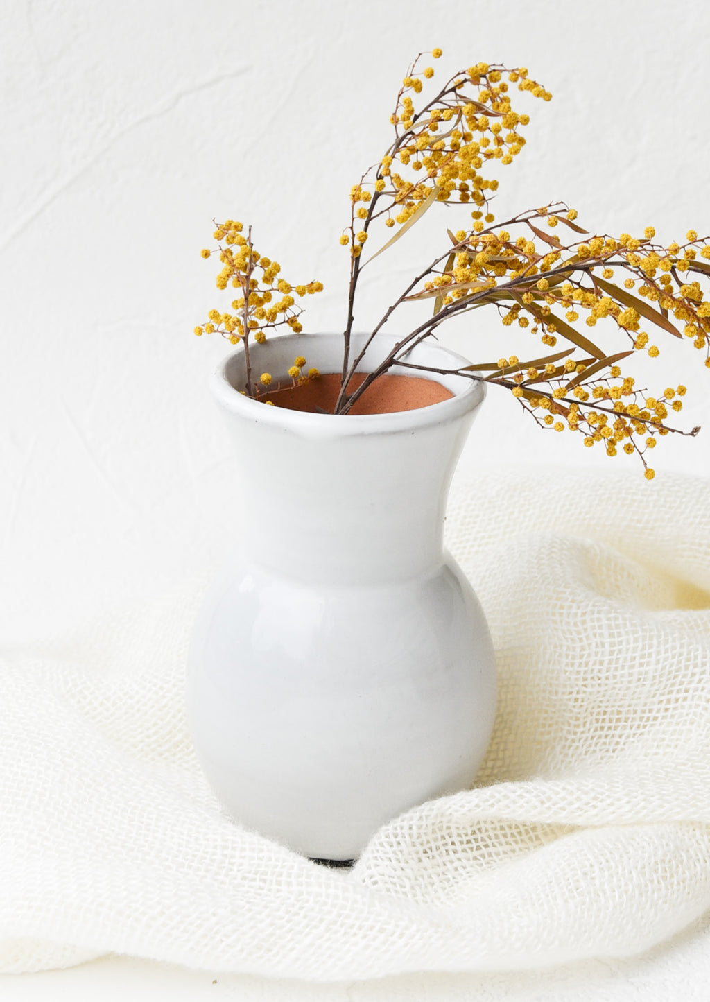 2: Glossy white ceramic vase with wide bottom and tapered top, with floral arrangement