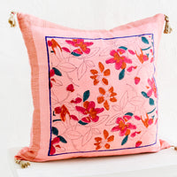 1: A square throw pillow in pink linen with a bordered floral block print pattern.