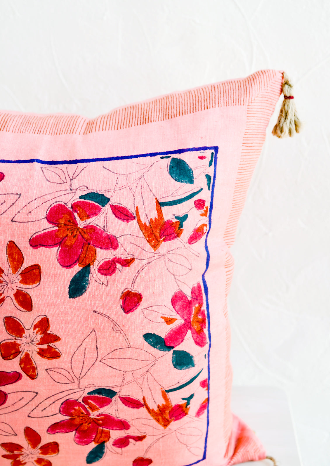 An intricate block printed floral pattern on a linen pillow.