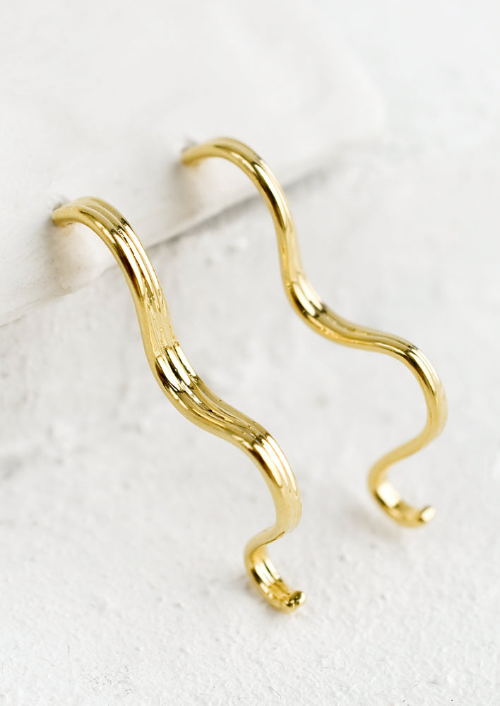1: A pair of gold earrings in curved design.