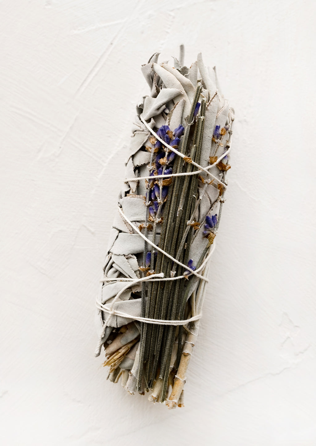 White Sage & Lavender: A sage smudge stick wrapped in white thread with dried lavender.