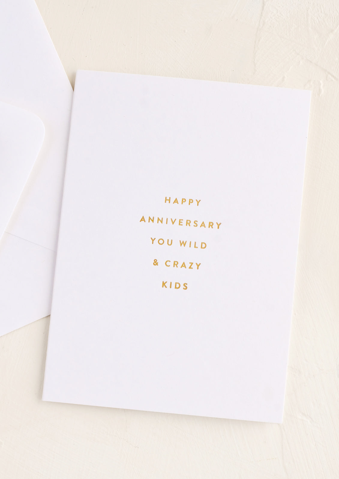 An anniversary greeting card in white with gold text.