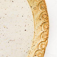 3: Detailed rim etching on ceramic platter.