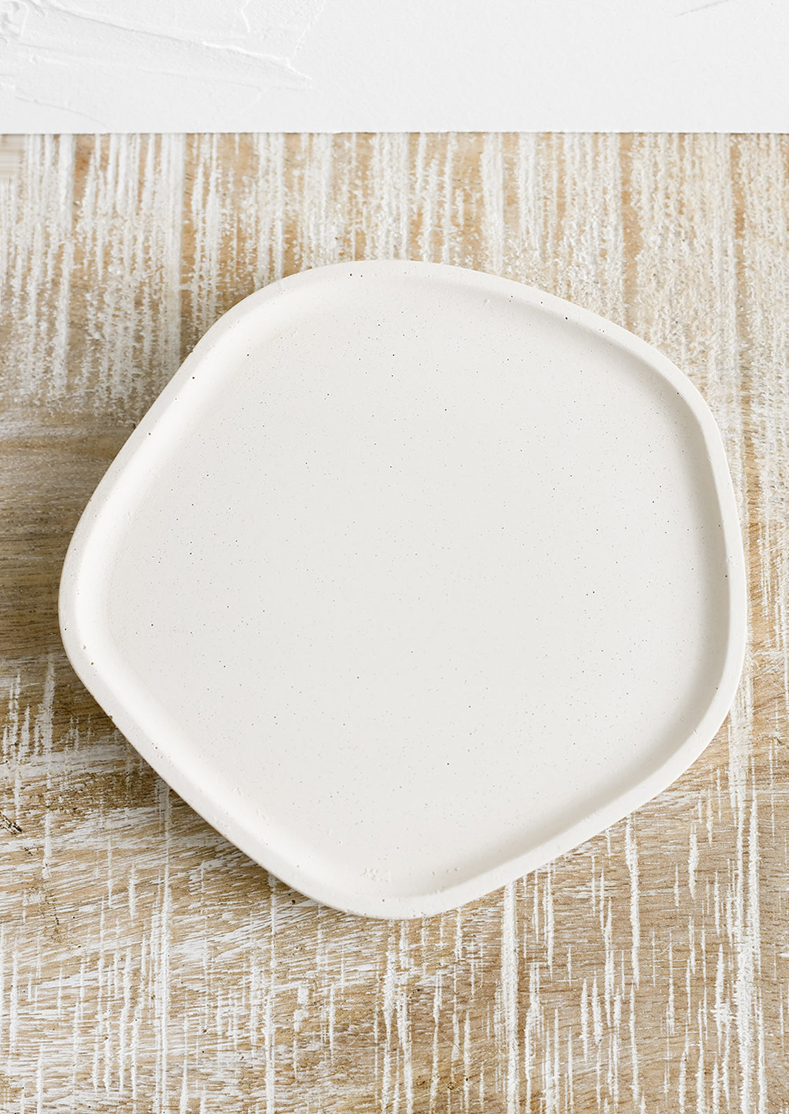 A small concrete tray in asymmetrical shape in cream.