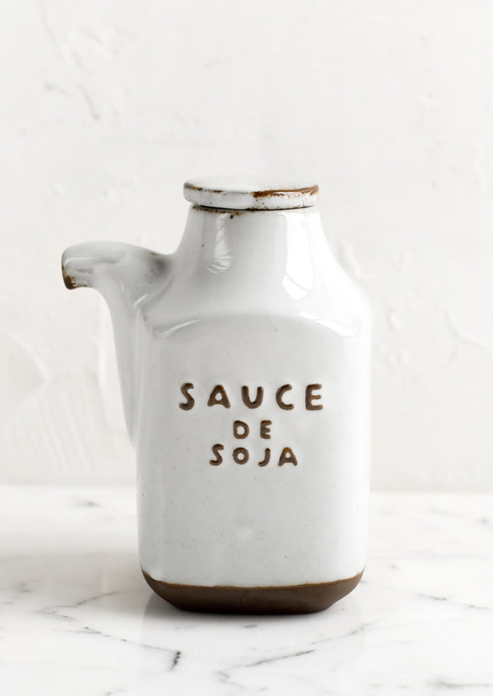 1: A small white and brown ceramic cruet jar with "Sauce de soja" text.