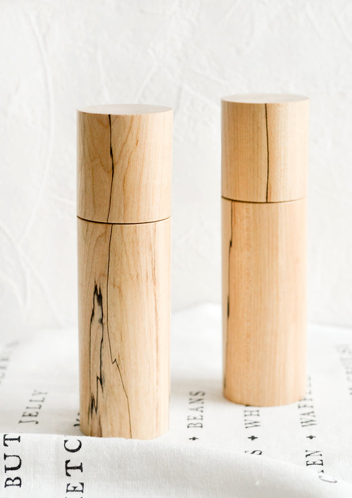 1: Two cylindrical pepper grinder mills in spalted maple wood.
