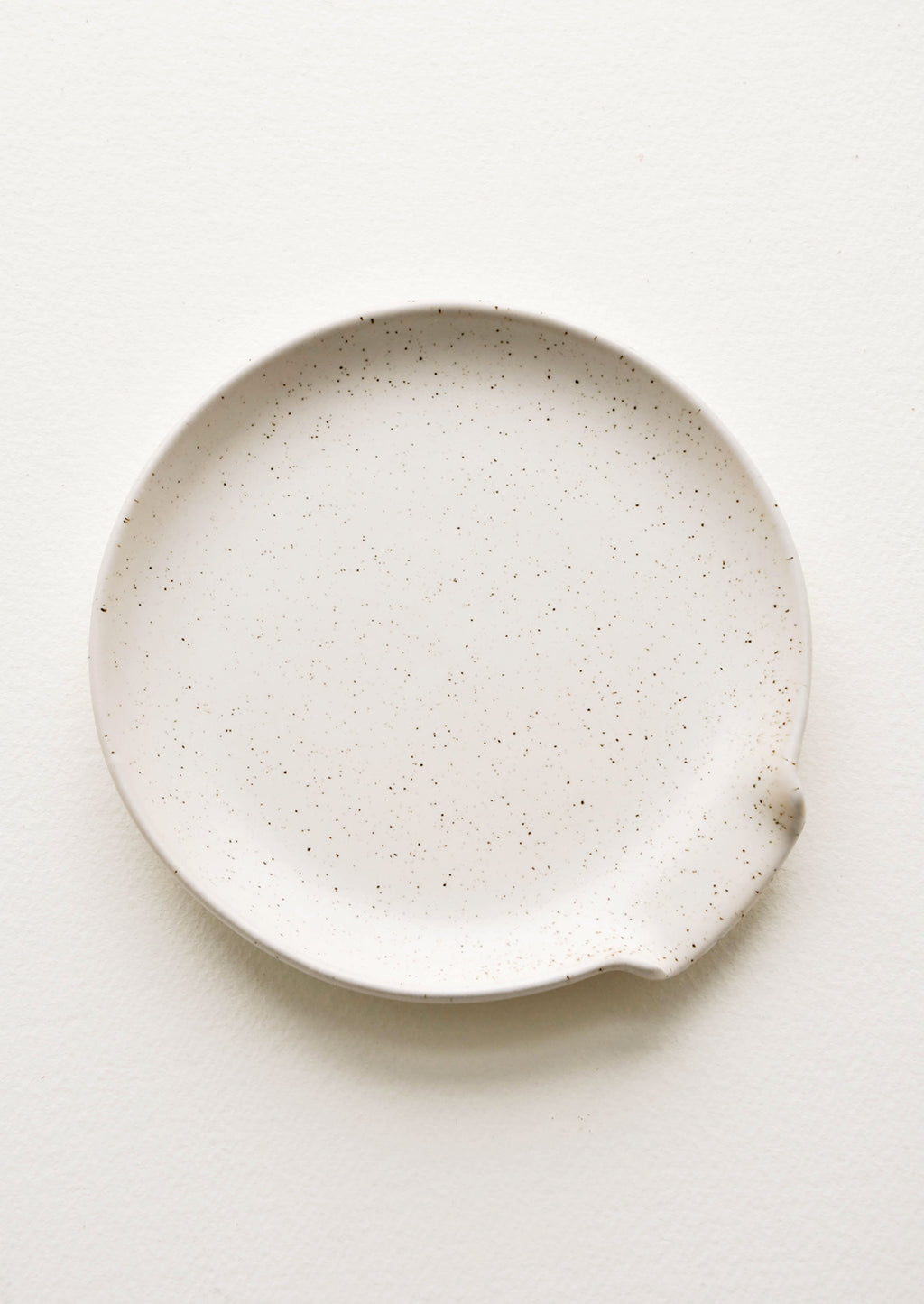 Natural: Circular ceramic spoon rest in ivory with tiny black speckles