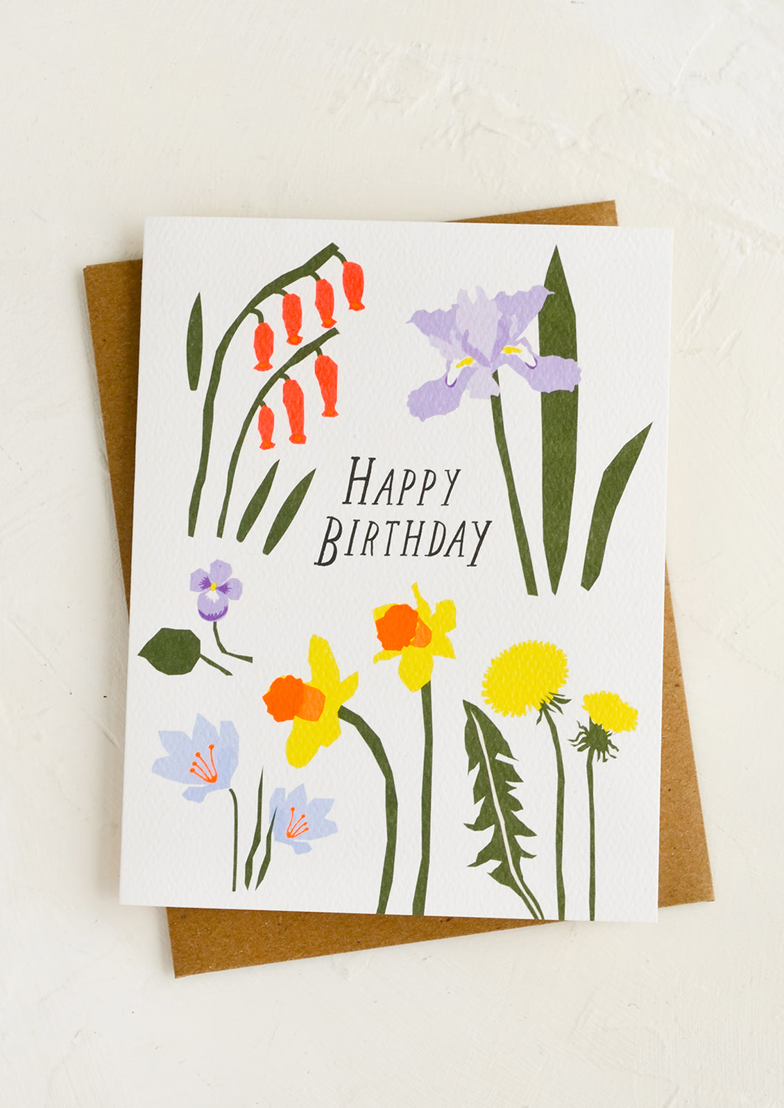 A birthday card with floral print and kraft envelope.