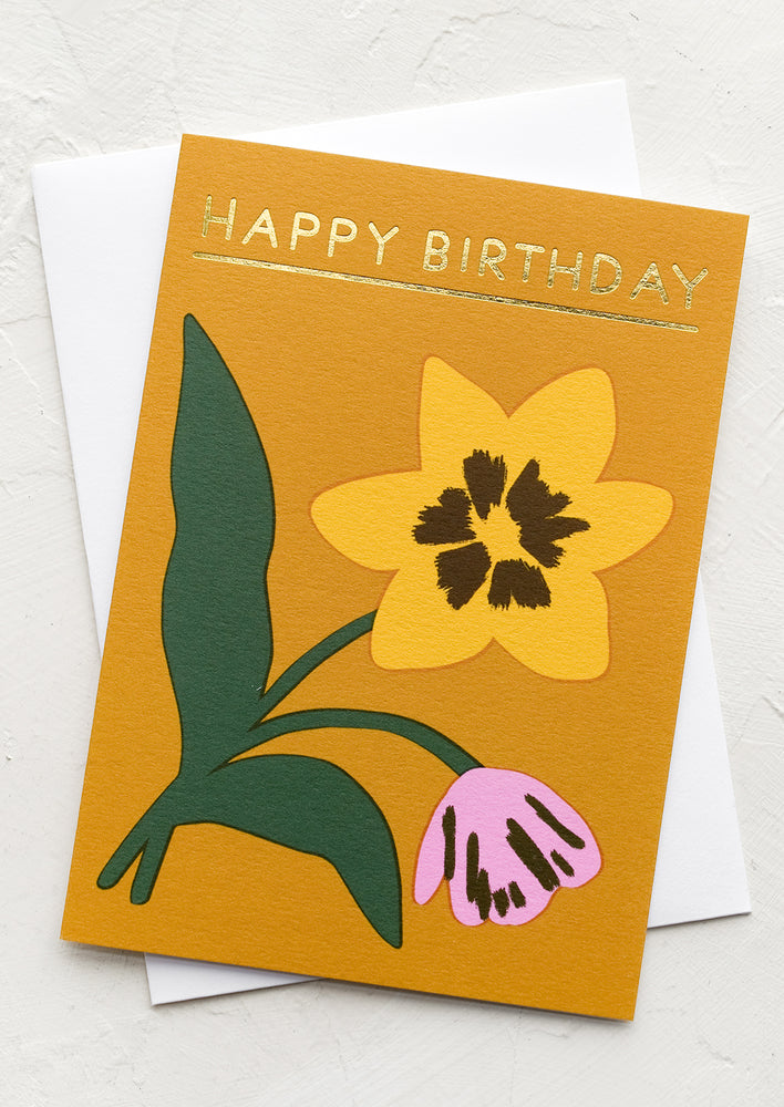 A mustard card with daffodil and tulip drawing, text at top reads "Happy Birthday".