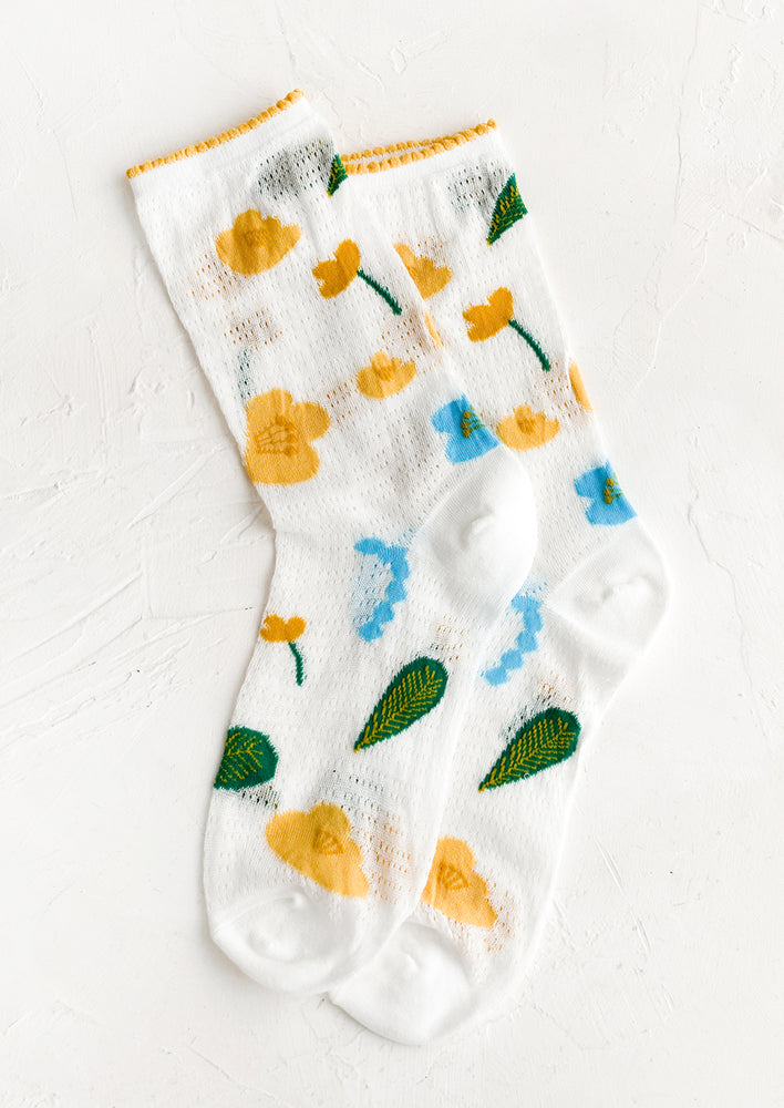 1: A pair of white mesh socks with blue, yellow and green floral print.