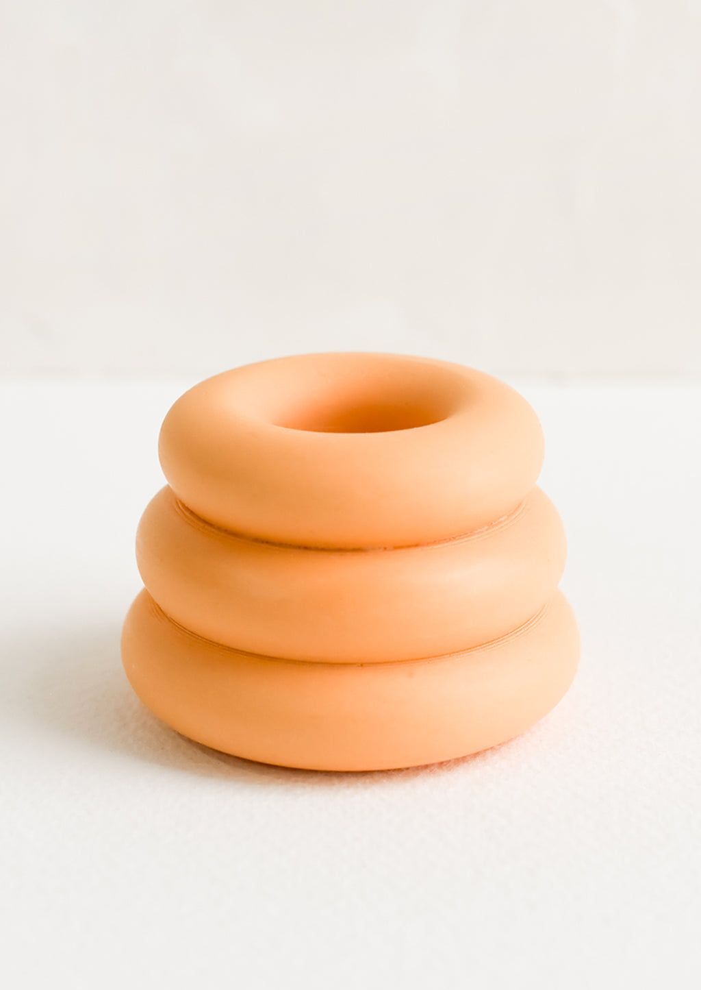 Sherbet: A taper candle holder with 3-layer stacked donut shape in sherbet orange.
