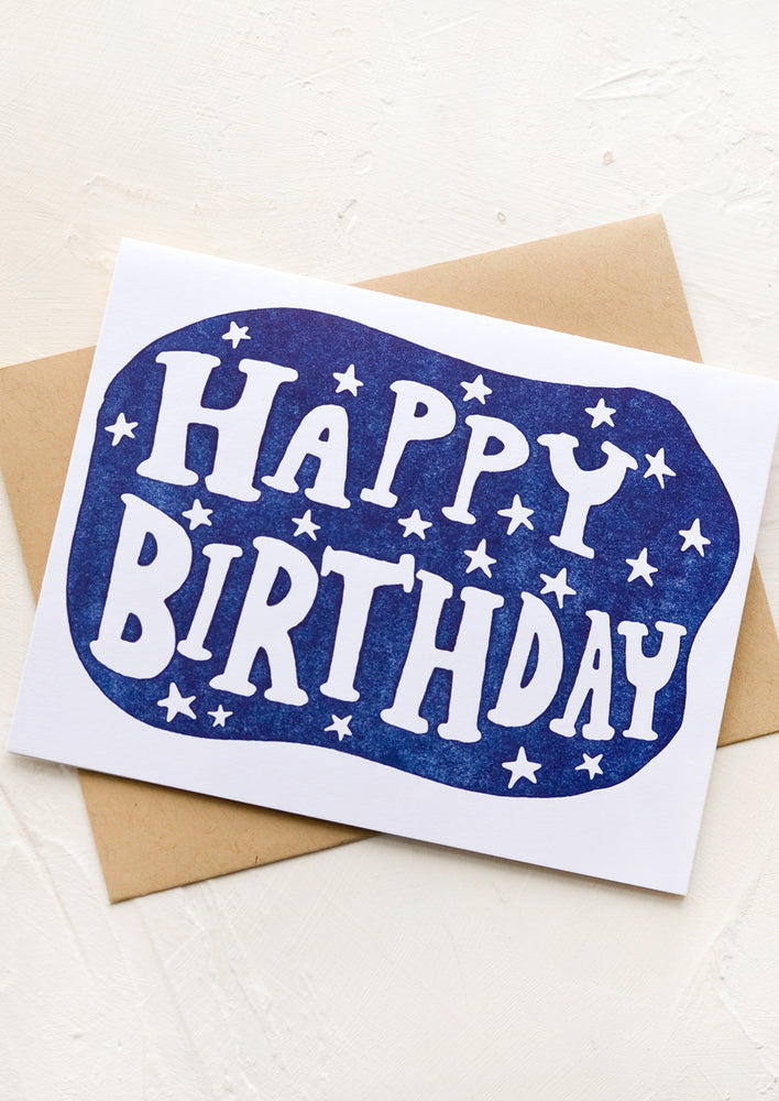 A greeting card with blue background and star print with "Happy birthday" text.
