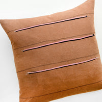 1: Throw pillow in reddish brown fabric with thin black stripes and sewn-on pink and black stripes
