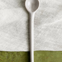1: A stoneware spoon in white with dark speckles.