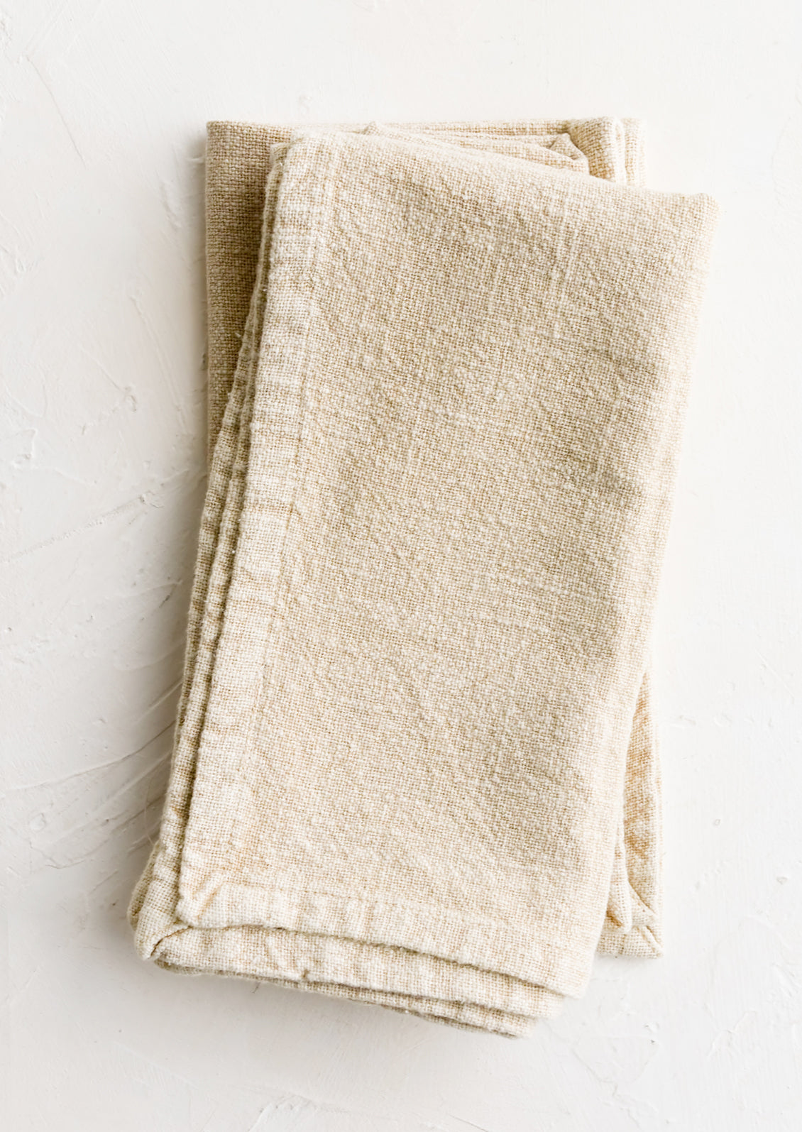 A pair of stonewashed napkins in oatmeal.