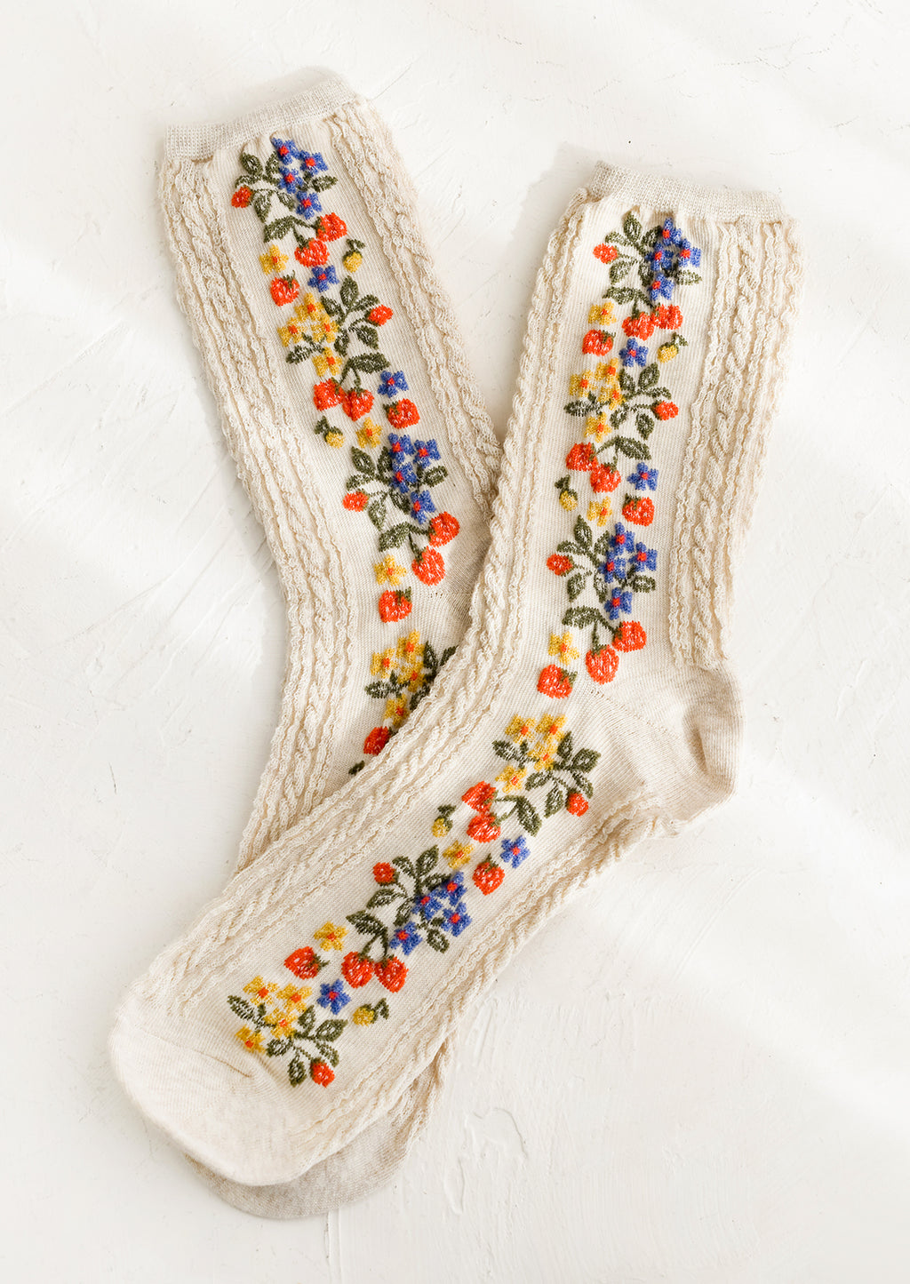 1: A pair of oatmeal colored socks with primary color strawberry print.