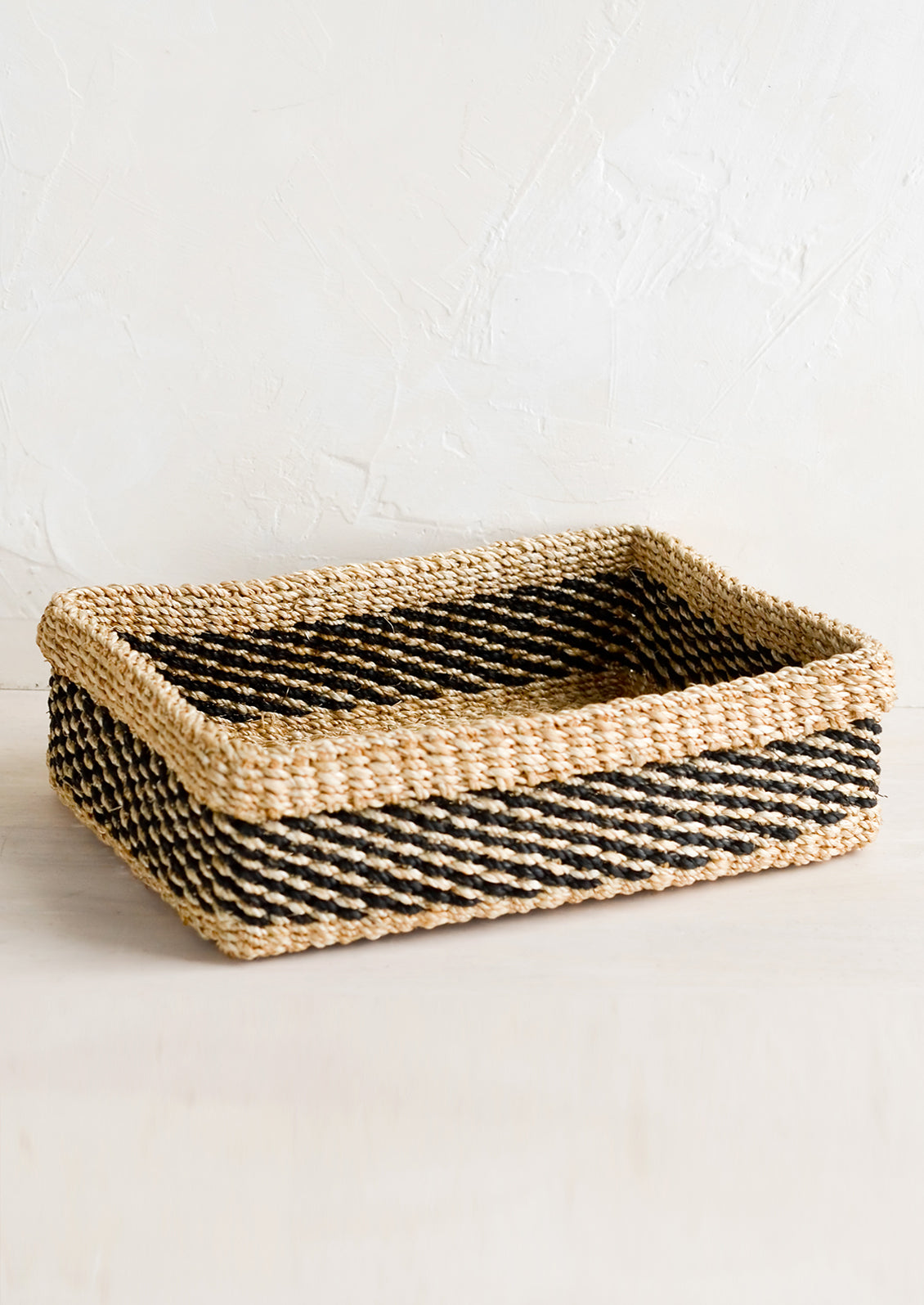 A structured rectangular storage tray in natural with black dashes.