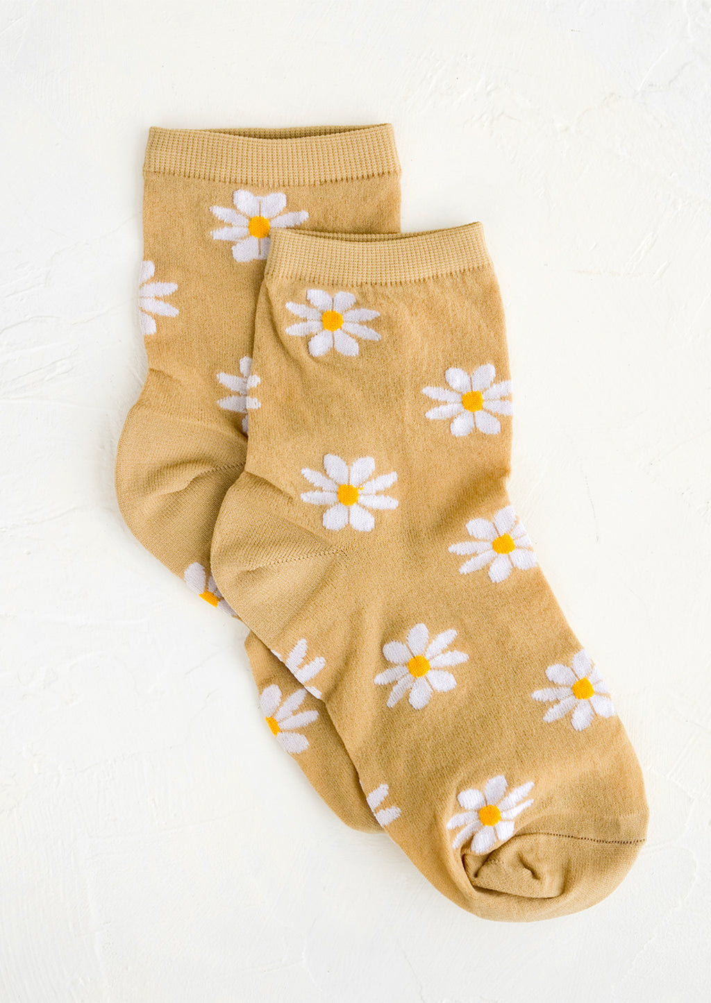 Tan: A pair of tan socks with white daisy pattern.