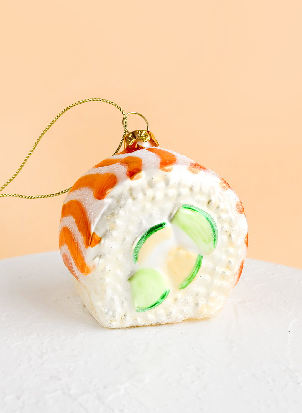 2: A decorative glass ornament in the shape of salmon avocado sushi roll.