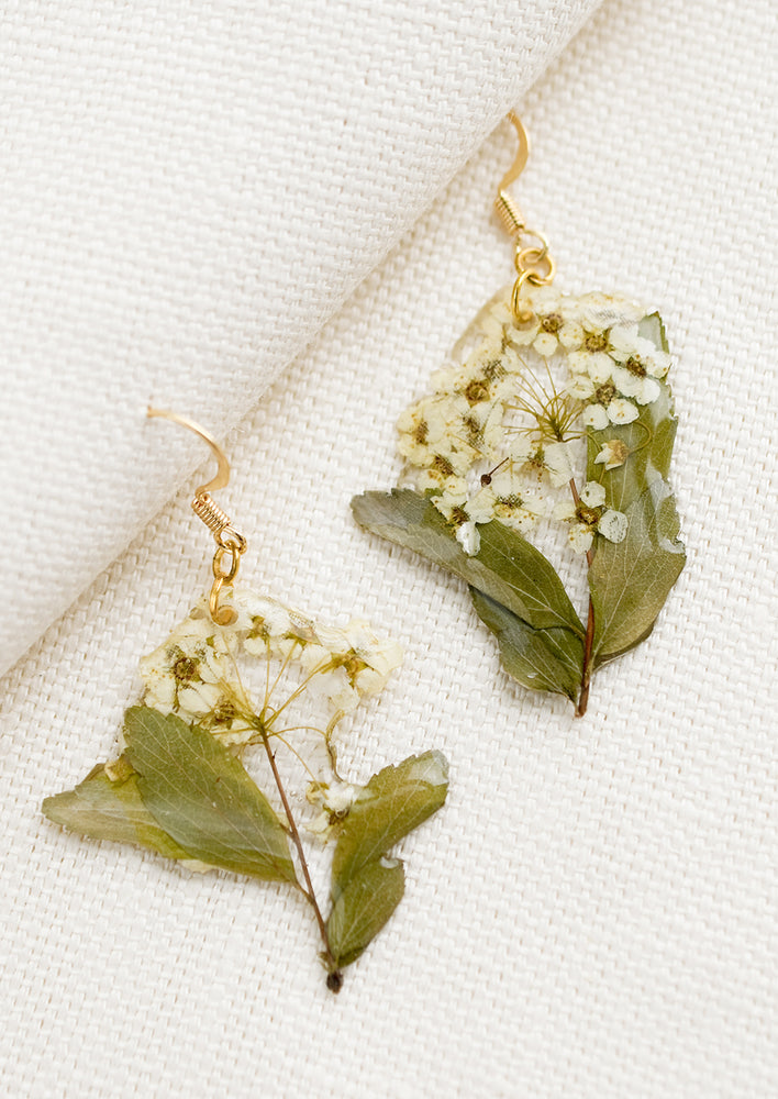 1: A pair of dried floral earrings in white.