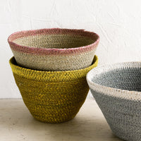 2: Three tapered storage baskets in assorted colors.