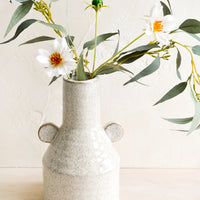 2: A speckled ceramic vase with flowers.