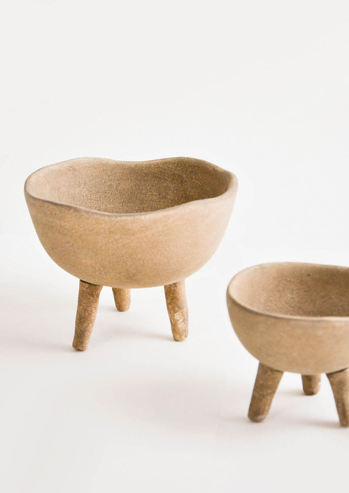 Brown ceramic bowls in natural clay with three footed legs