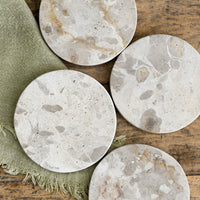 2: A set of round, beige marble coasters.