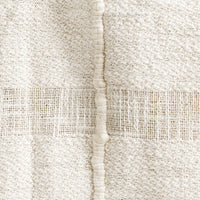 2: A natural cotton throw with paneling detailing.