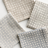 1: A set of four napkins in assorted colors with tile mosaic print.