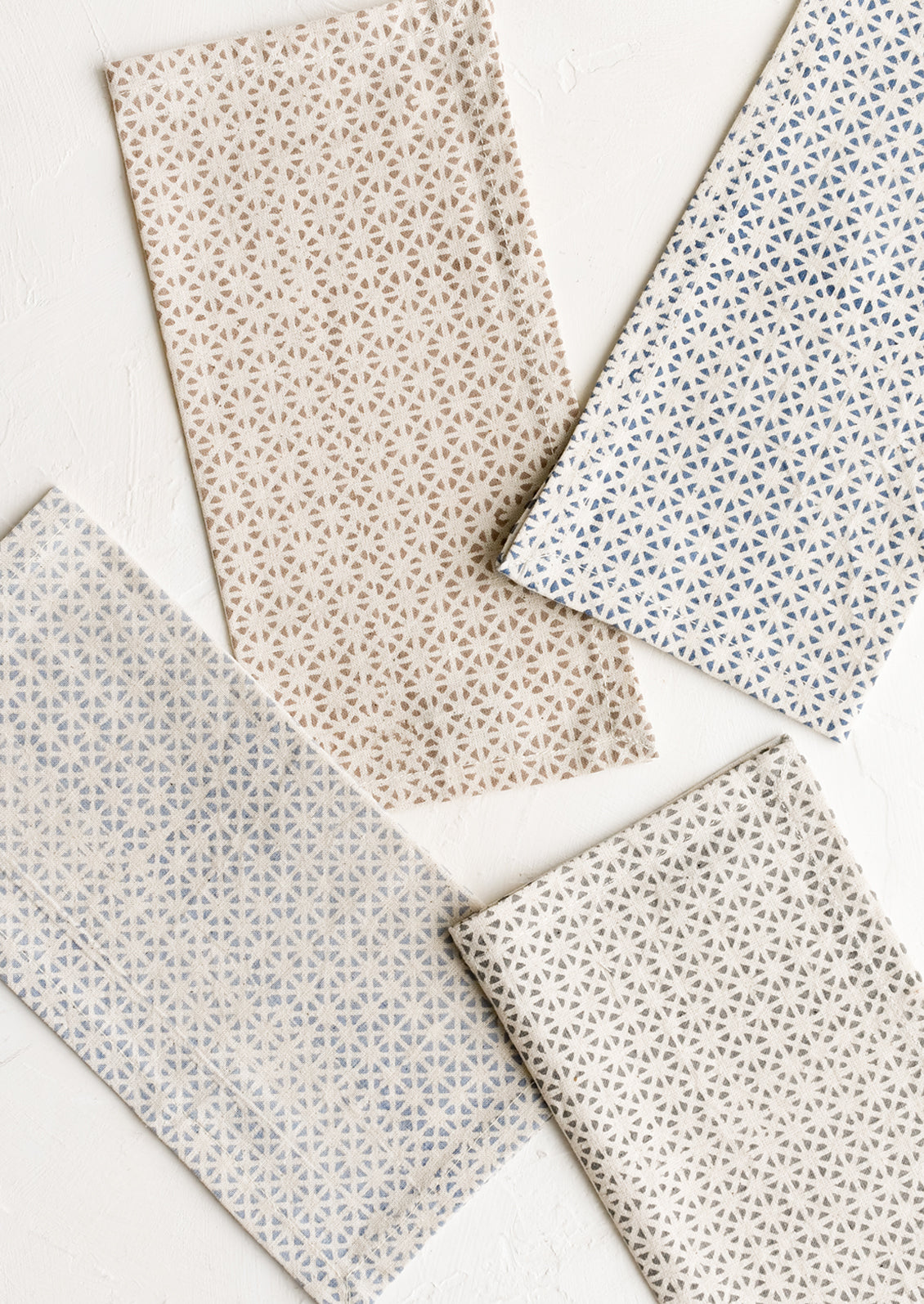 A set of four napkins in assorted colors with tile mosaic print.