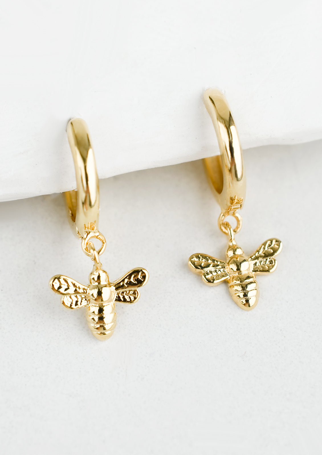 Gold huggie hoops with bee charm.