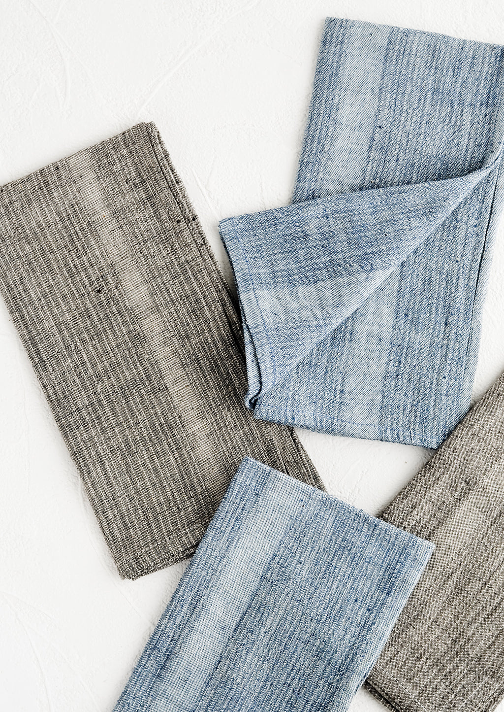4: Fabric napkins in indigo and charcoal with textured tonal stripe pattern.