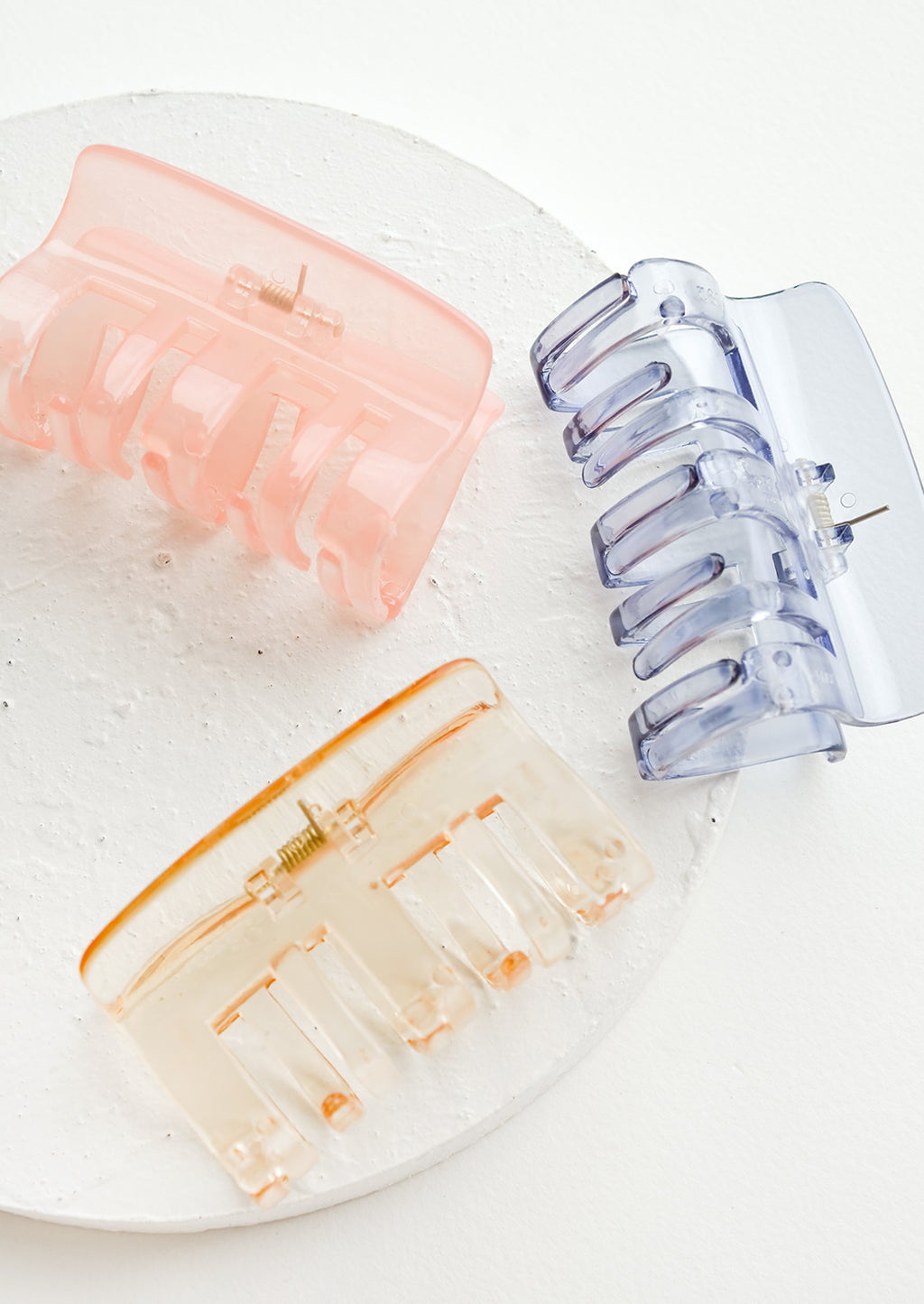 1: Three transparent hair claws in an assortment of colors.
