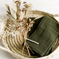 2: A palm leaf tray holding dried flowers and napkins.